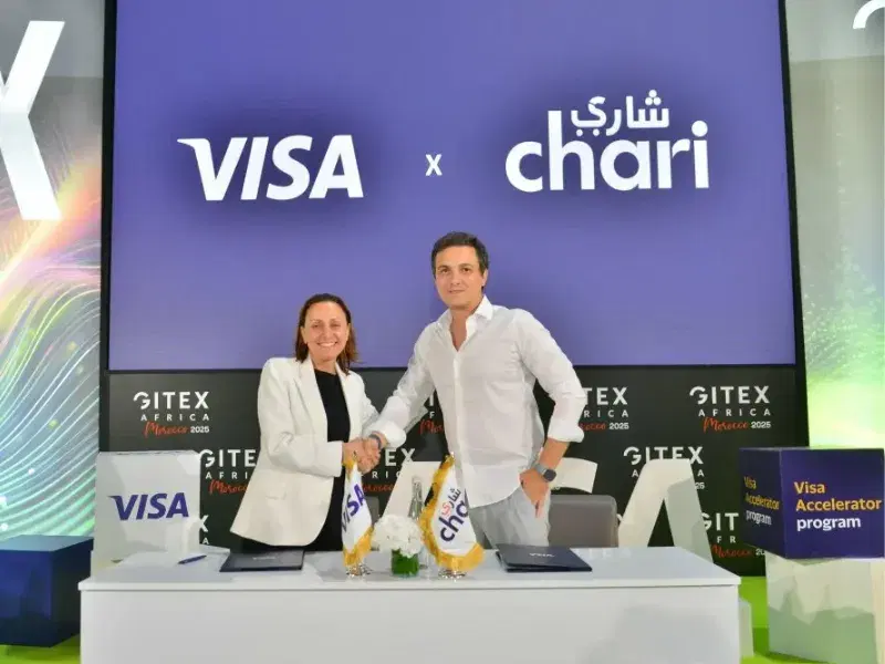 Poignée de main entre représentants de Visa et de Chari sur le stand Visa × Chari, GITEX Africa Morocco 2025 (programme Visa Accelerator)